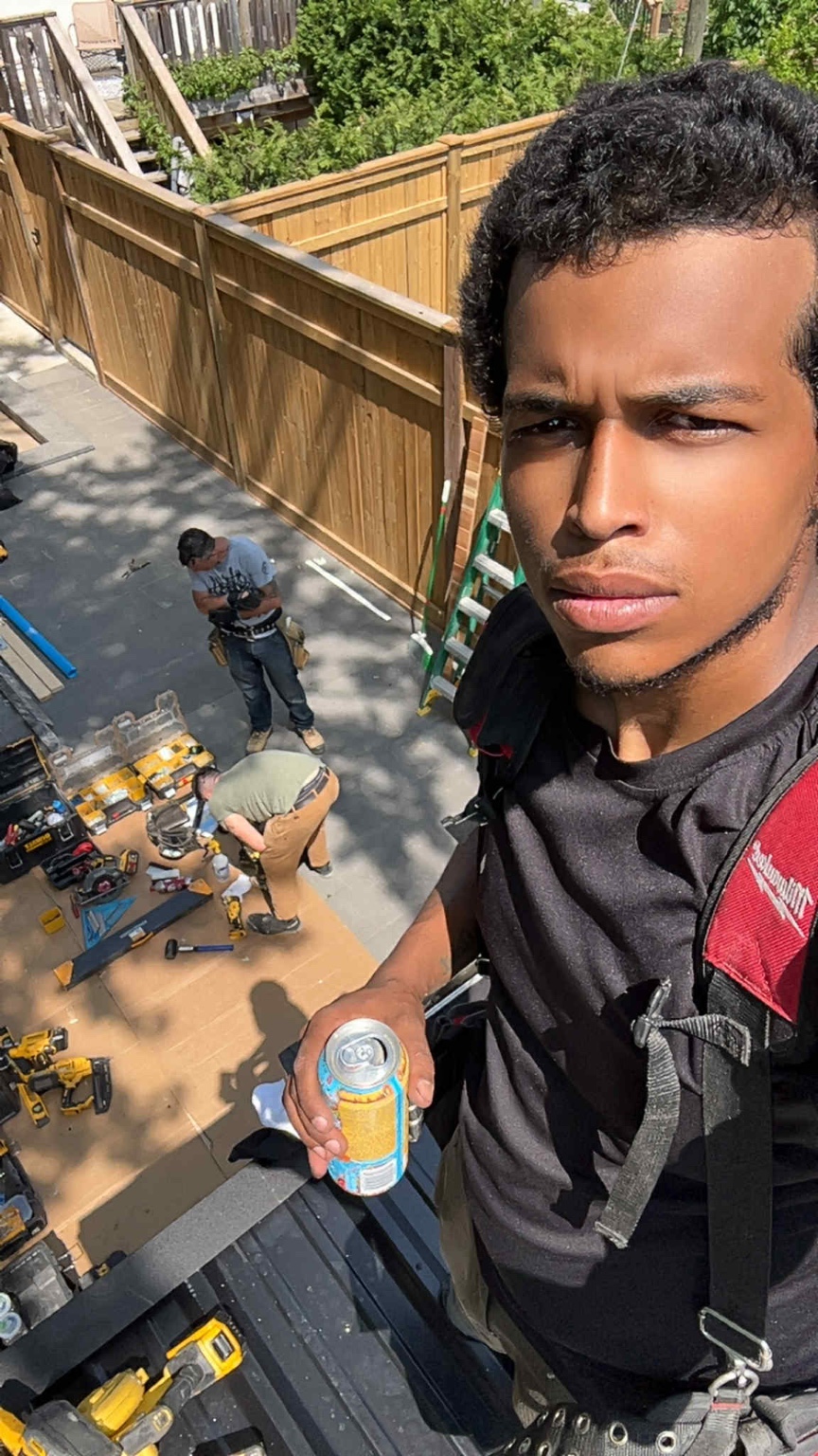 Adean Wilkins on an active fencing project with his crew working below